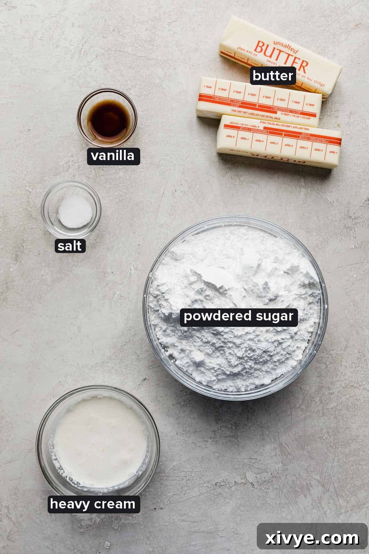 Ingredients for the luscious Funfetti Cake frosting, displayed in glass bowls on a clean light gray surface.