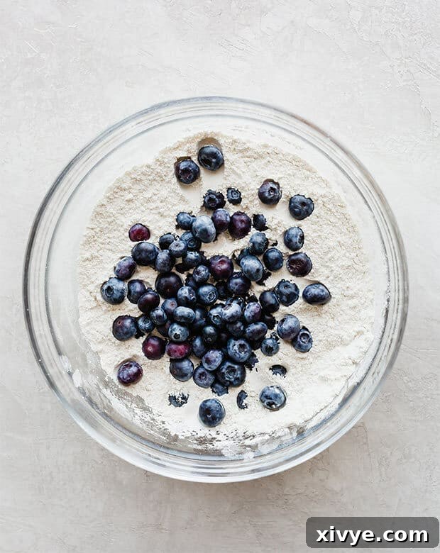 Sunrise Buttermilk Blueberry Muffins 4 Glass bowl with dry ingredients and fresh blueberries for making easy blueberry muffins.
