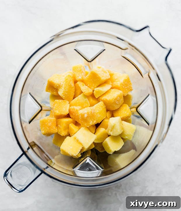 A blender full of frozen mango chunks in preparation for making mango sorbet.