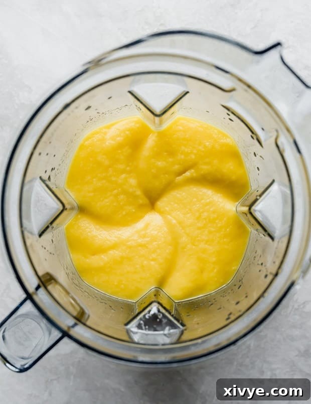 A blender full of freshly blended mango puree.