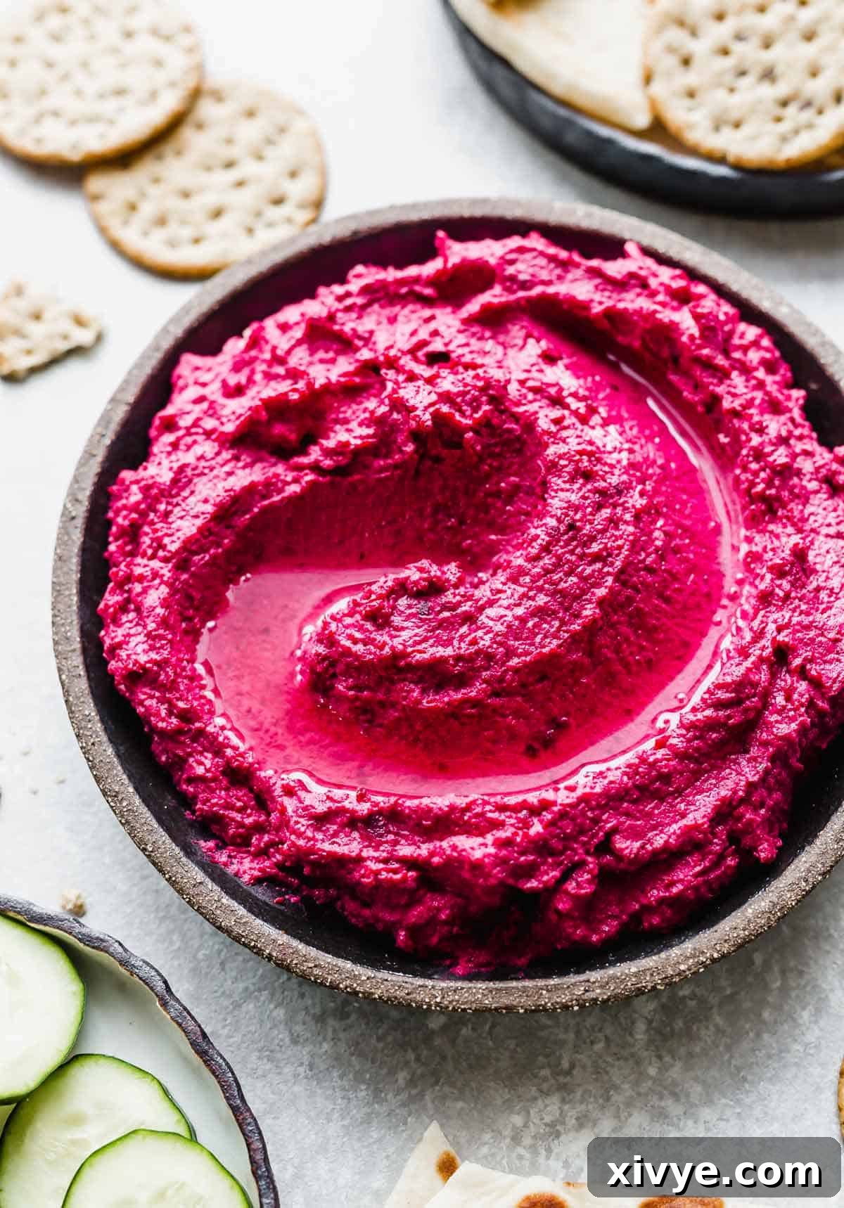 Beet Hummus on a black plate.