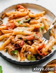 Pizza casserole with peppers and pepperoni on a white plate.