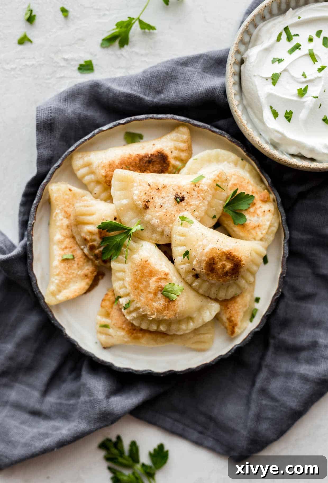 Homemade Pierogies on a plate with chives.