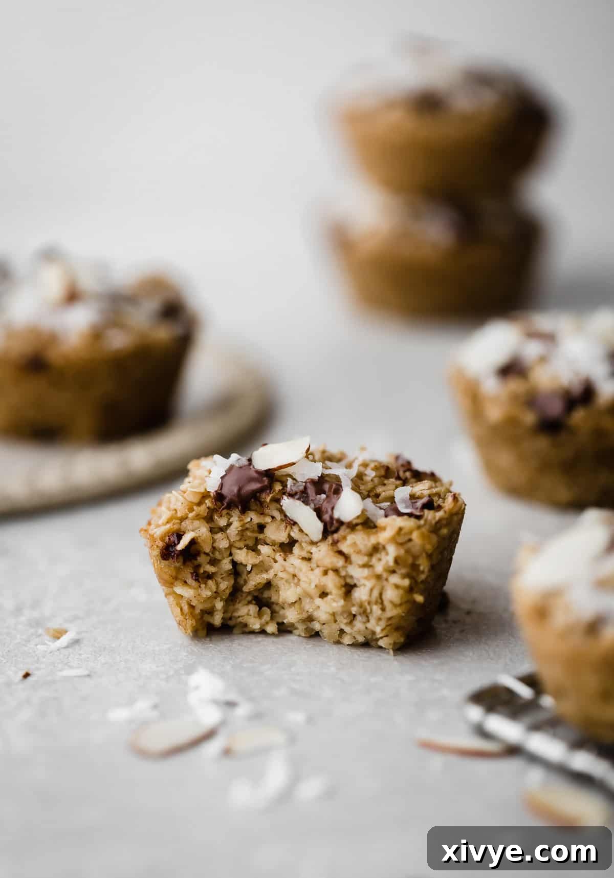 A baked oatmeal cup topped with chocolate chips with a bite taken out of the oatmeal cup.