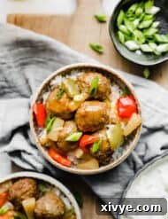 A bowl of sweet and sour meatballs topped with green onions, ready for serving.
