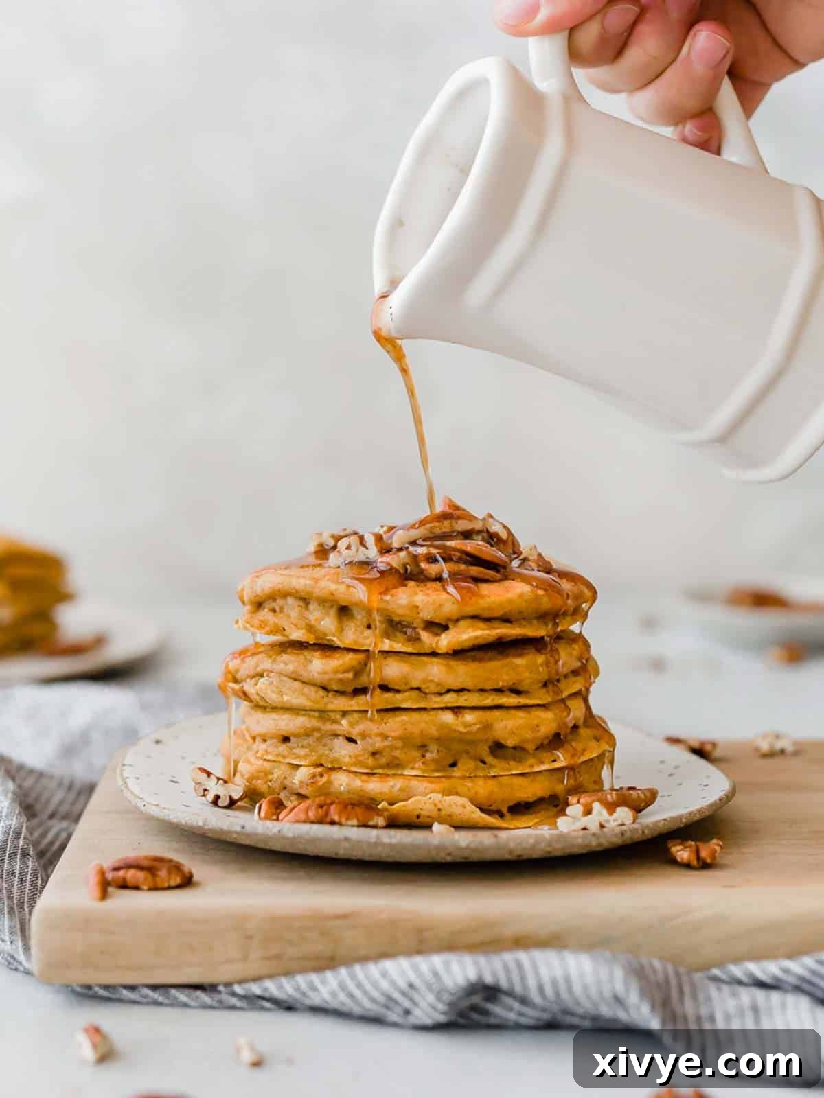 Spiced Pumpkin Pecan Pancakes 8 Homemade pecan pancakes syrup being poured over a stack of fluffy pumpkin pancakes. The perfect finishing touch.
