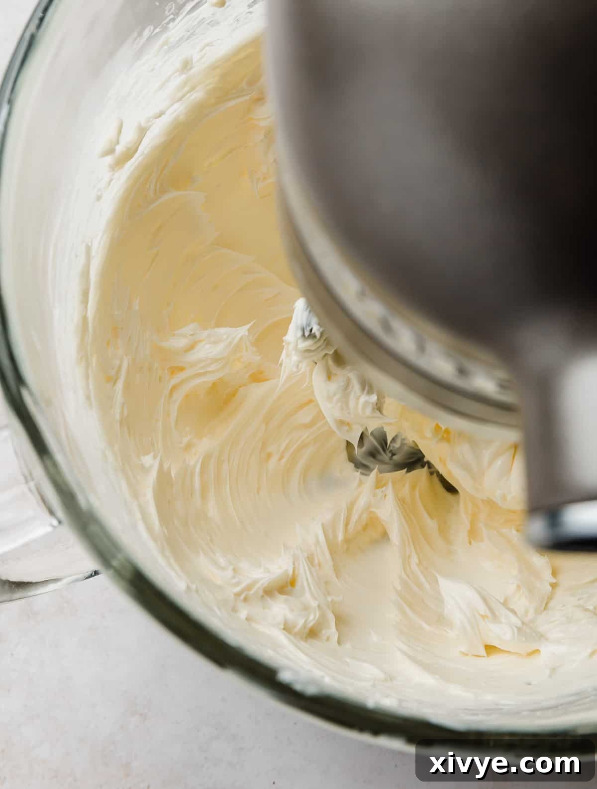 Decadent Chocolate Buttercream 5 Unsalted butter being creamed in a stand mixer bowl with a paddle attachment, turning pale and fluffy.