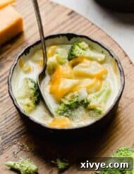 A bowl of cheesy Broccoli Potato Soup in a black-rimmed bowl.