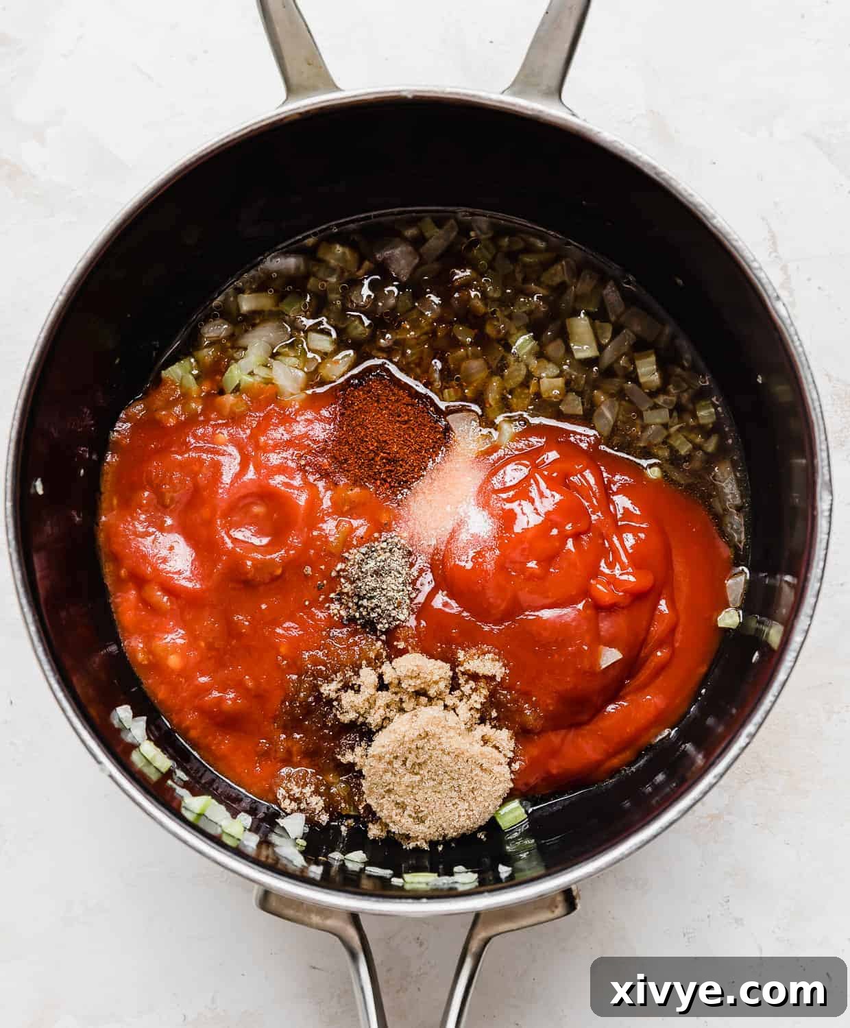 A collection of ingredients for the homemade BBQ sauce, including salsa, ketchup, and various spices, mixed together in a saucepan before simmering.