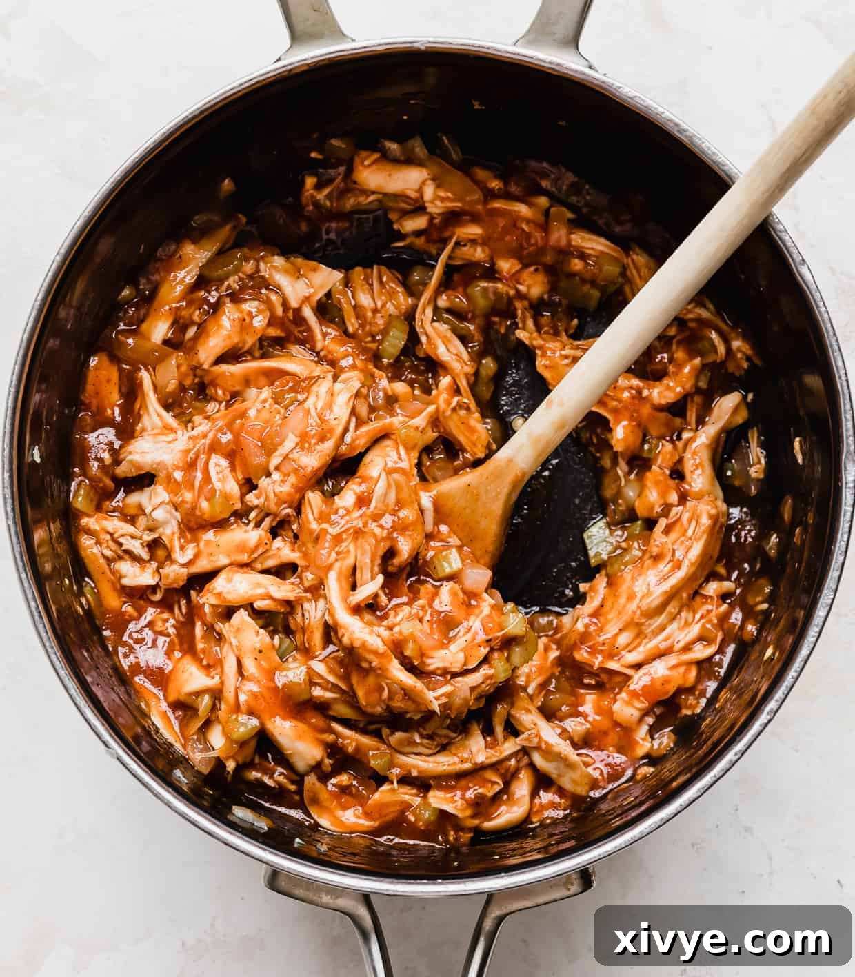 The BBQ chicken sandwich sauce and filling simmering gently in a saucepan, ready for serving.