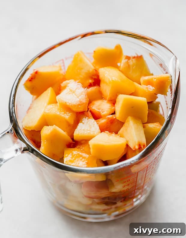 Sun-Kissed Peach Indulgence 3 A glass liquid measuring cup full of chopped peaches, ready for maceration.
