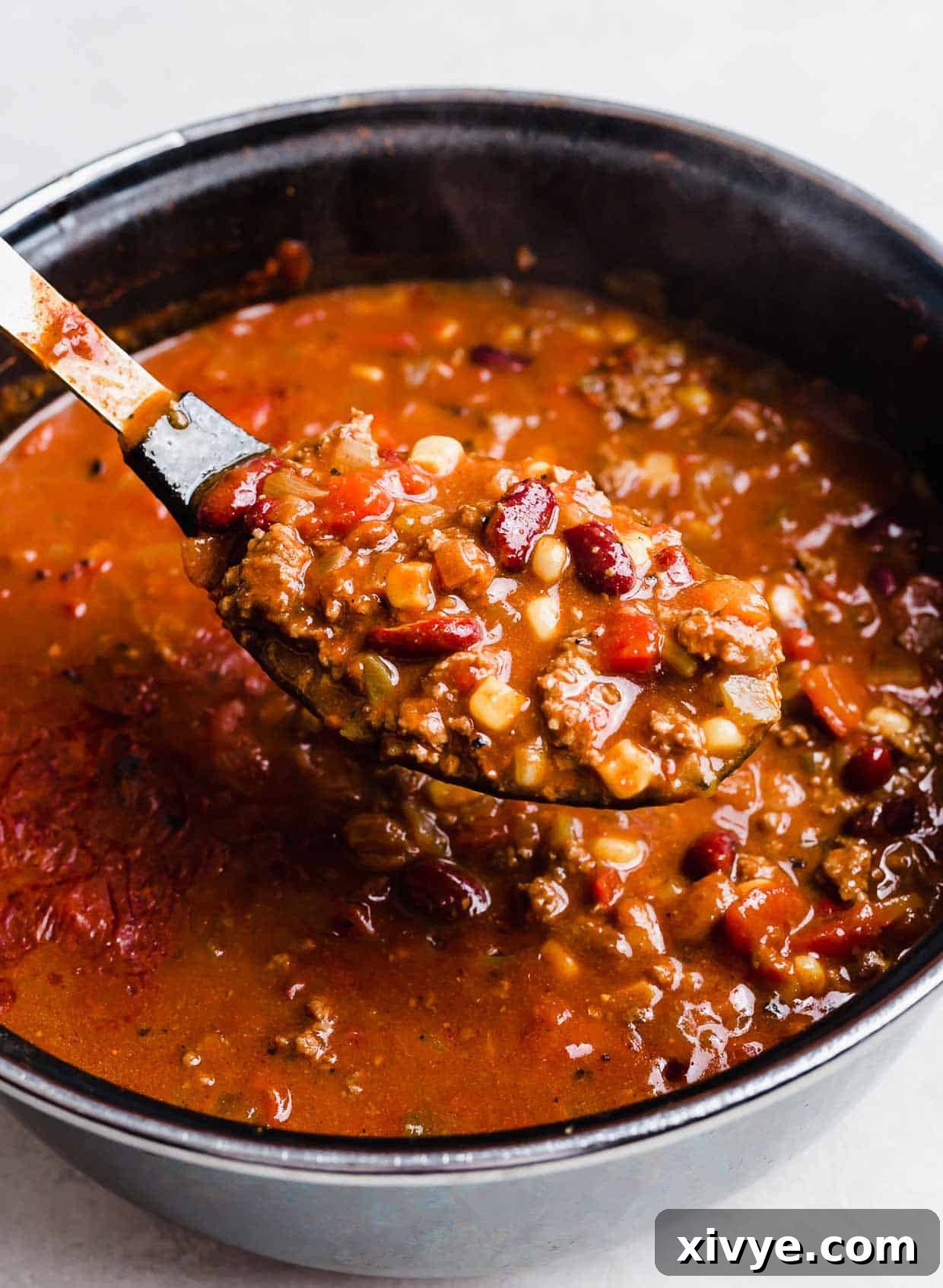 A serving spoon scooping up Taco Soup with Fritos.