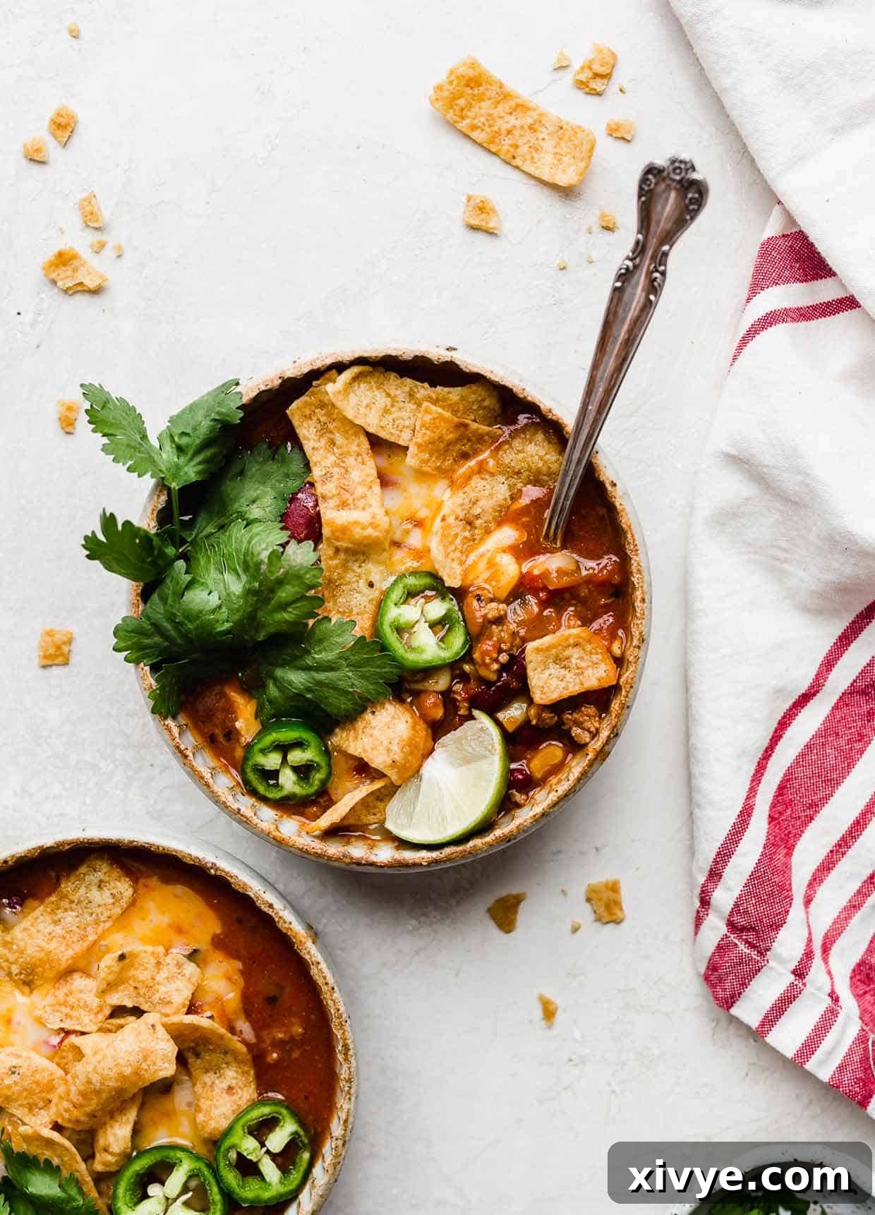 Overhead photo of a bowl of Taco Soup with Fritos and cilantro and lime wedge for garnish.