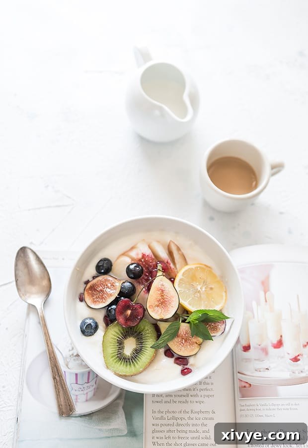 Hump Day Haven 2 A pristine white ceramic bowl elegantly showcasing a vibrant assortment of fresh, ripe fruits, including succulent blueberries, plump raspberries, and verdant green grapes, delicately arranged beside a gleaming silver spoon, inviting a healthy and delicious start to any day.
