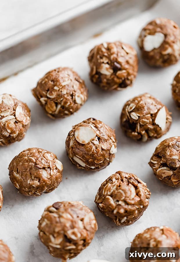 Hump Day Haven 4 A rustic wooden baking sheet generously filled with perfectly arranged, bite-sized healthy almond joy treats. Each treat features a delicious blend of toasted coconut, crunchy almonds, and a delicate drizzle of melted chocolate, showcasing their homemade appeal and readiness for enjoyment.