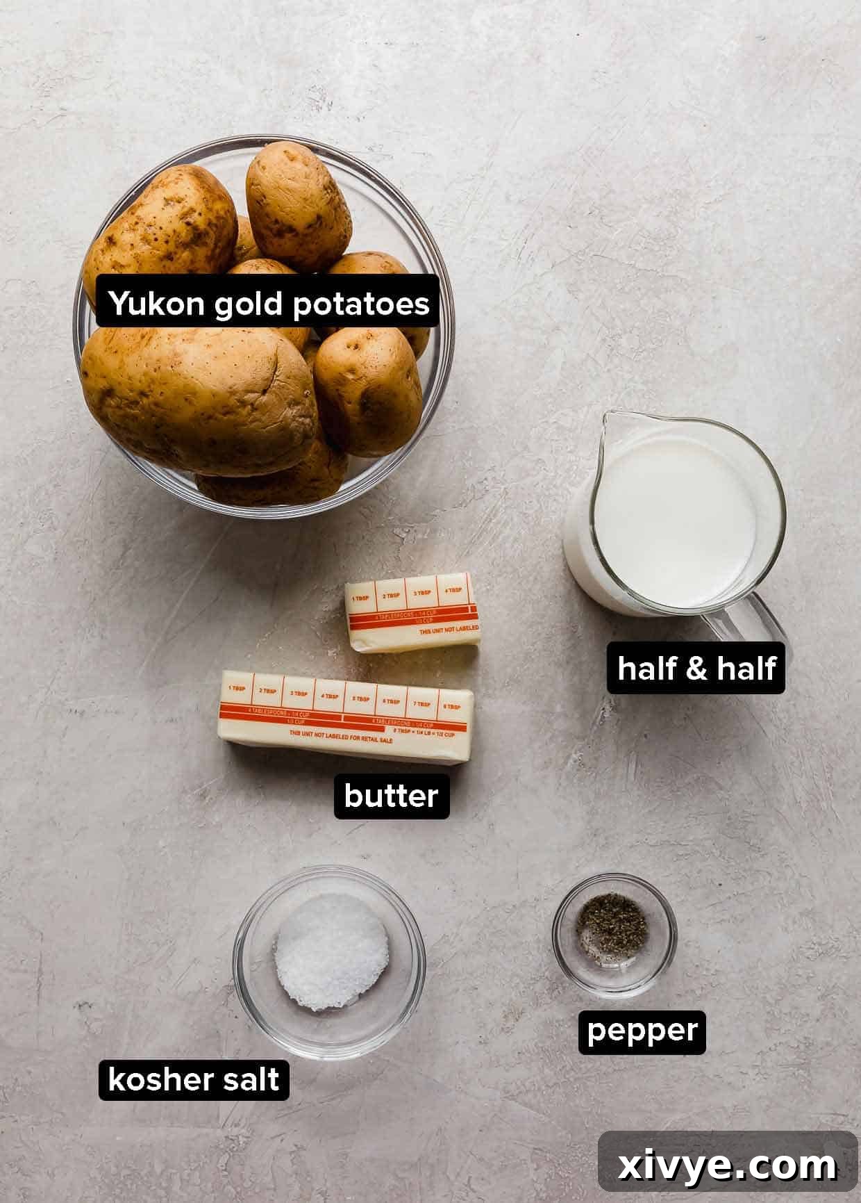 Mashed Potatoes with half and half ingredients: Yukon gold potatoes, half and half, butter, kosher salt, and pepper laid out on a kitchen counter.