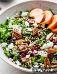 A kale and quinoa salad topped with feta cheese in a white bowl.