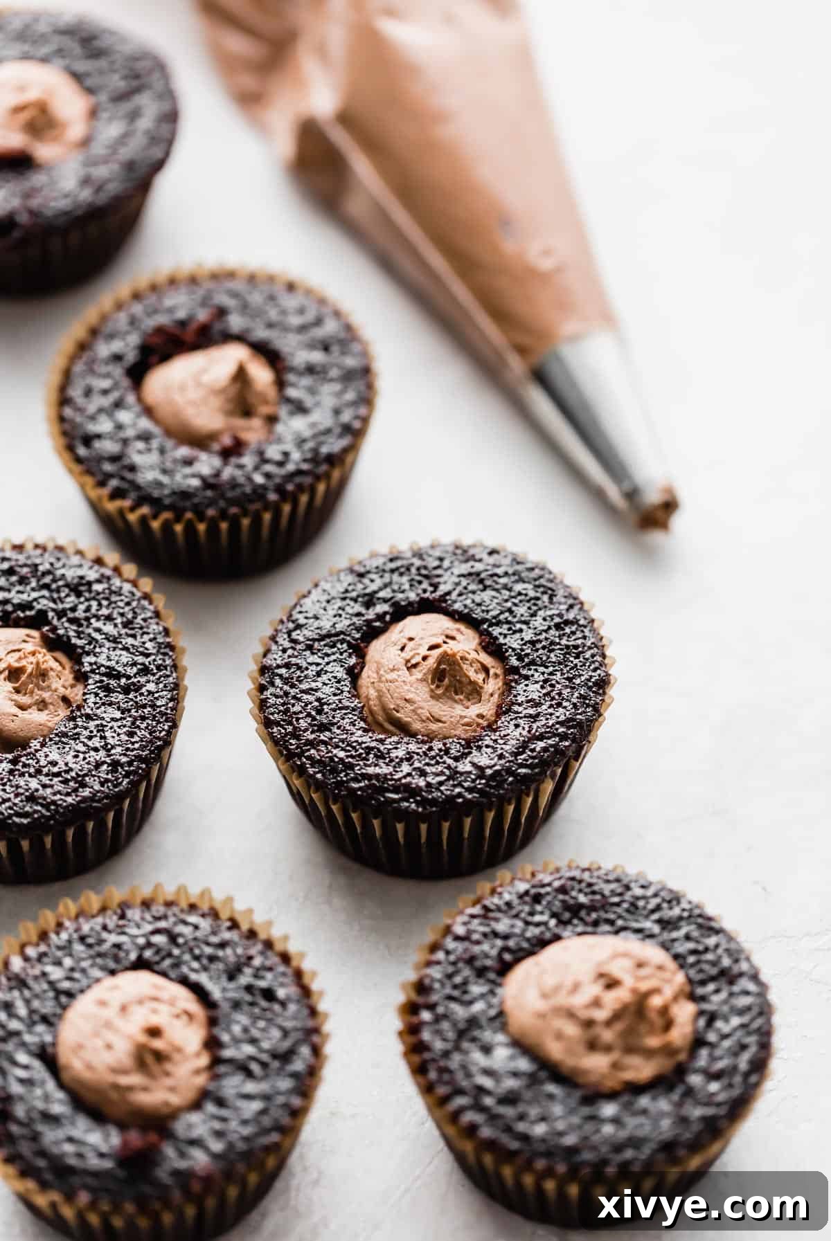 German Chocolate Cupcakes with the core removed and filled with a chocolate mousse frosting, showcasing the layered deliciousness.
