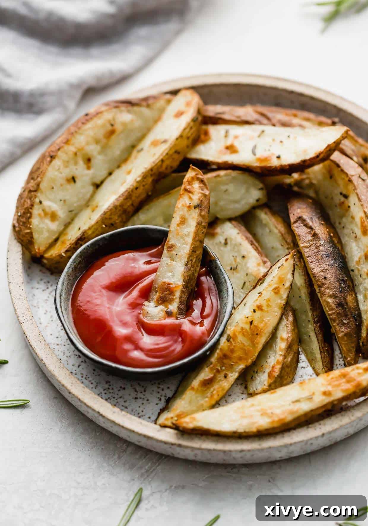 A Crispy Baked Potato Wedge dipped into a black small bowl of ketchup.