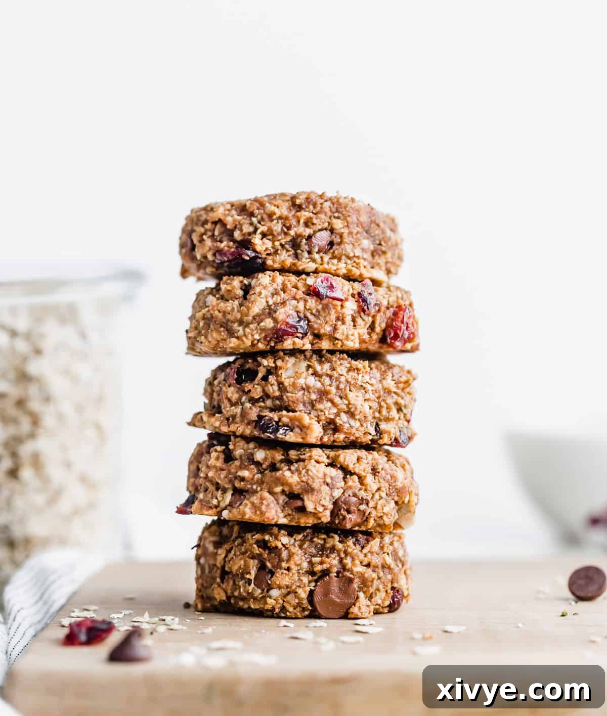 A stack of 5 Breakfast Cookies on a wooden cutting board. 