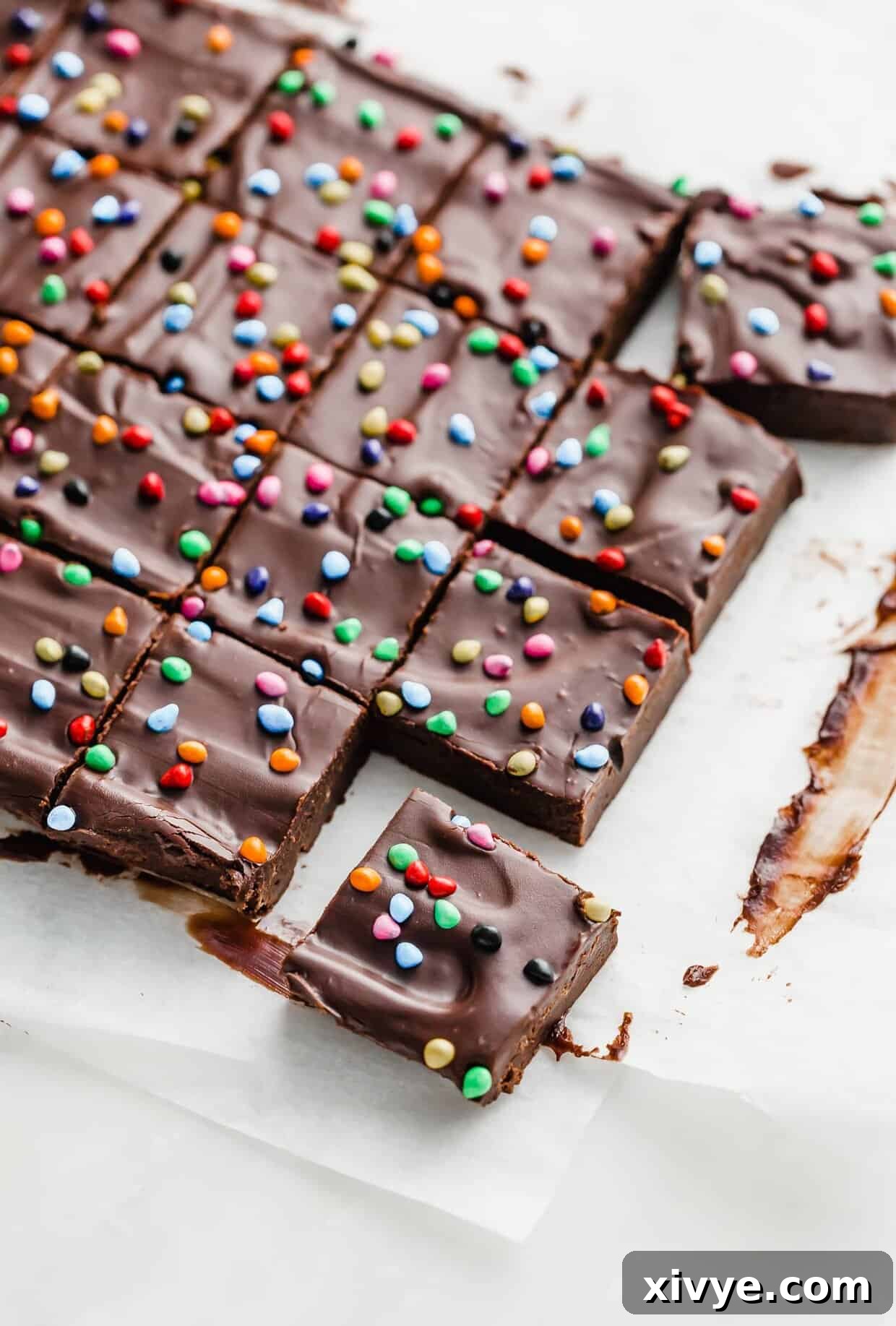 Cosmic Brownie Magic 14 Homemade Cosmic Brownies cut into squares on a white surface, showcasing the fudgy interior and vibrant topping.