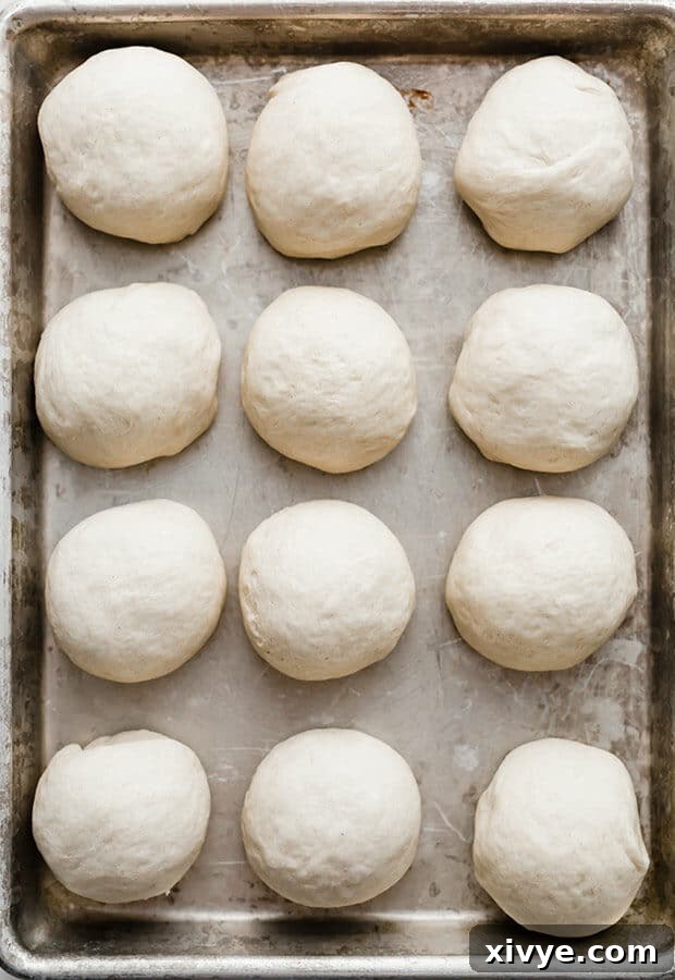 Irresistible Rosemary Garlic Parmesan Rolls 4 A baking sheet filled with round balls of unbaked roll dough