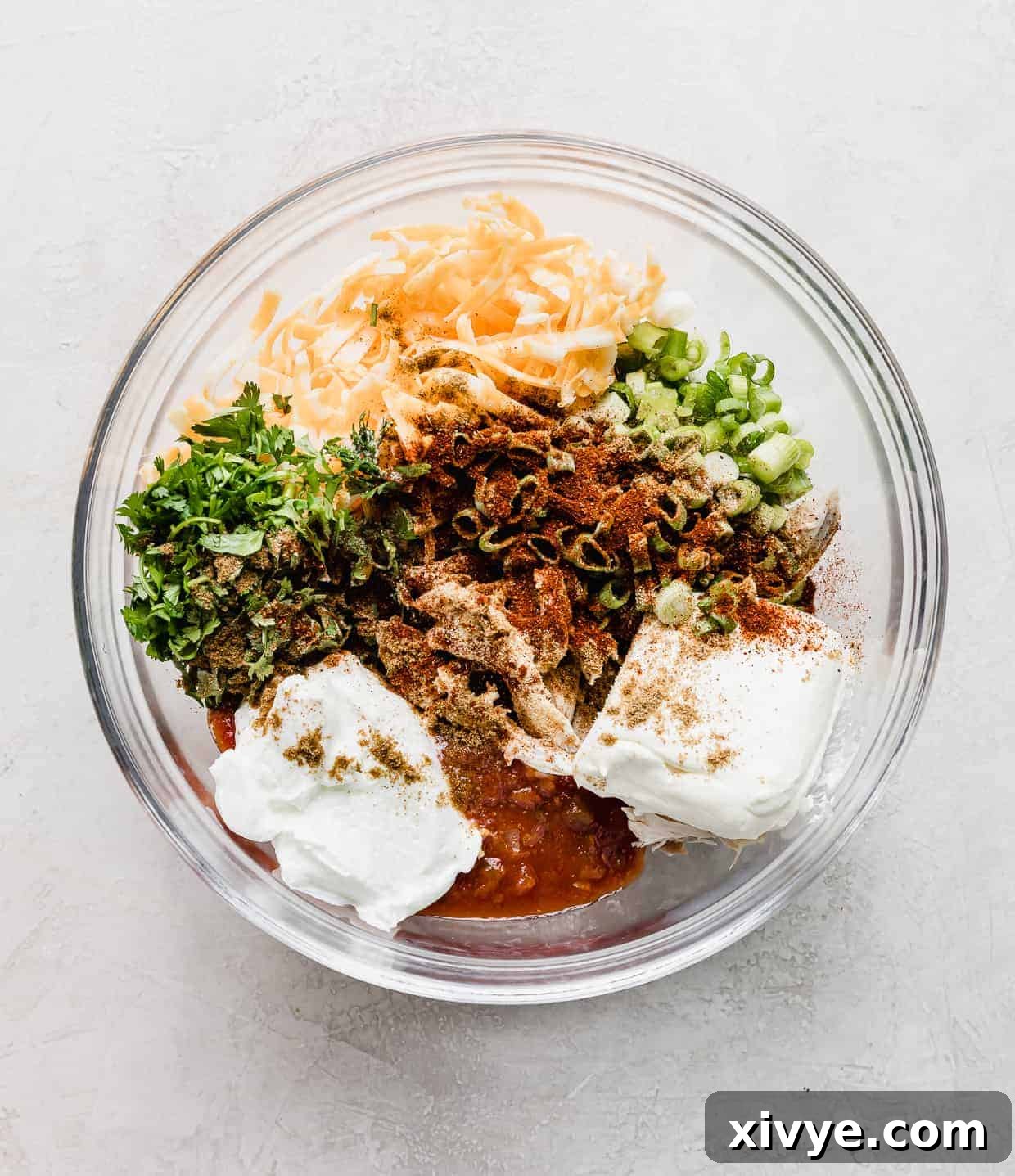 Baked Chicken Taquitos filling ingredients portioned separately in a glass bowl on a white background.