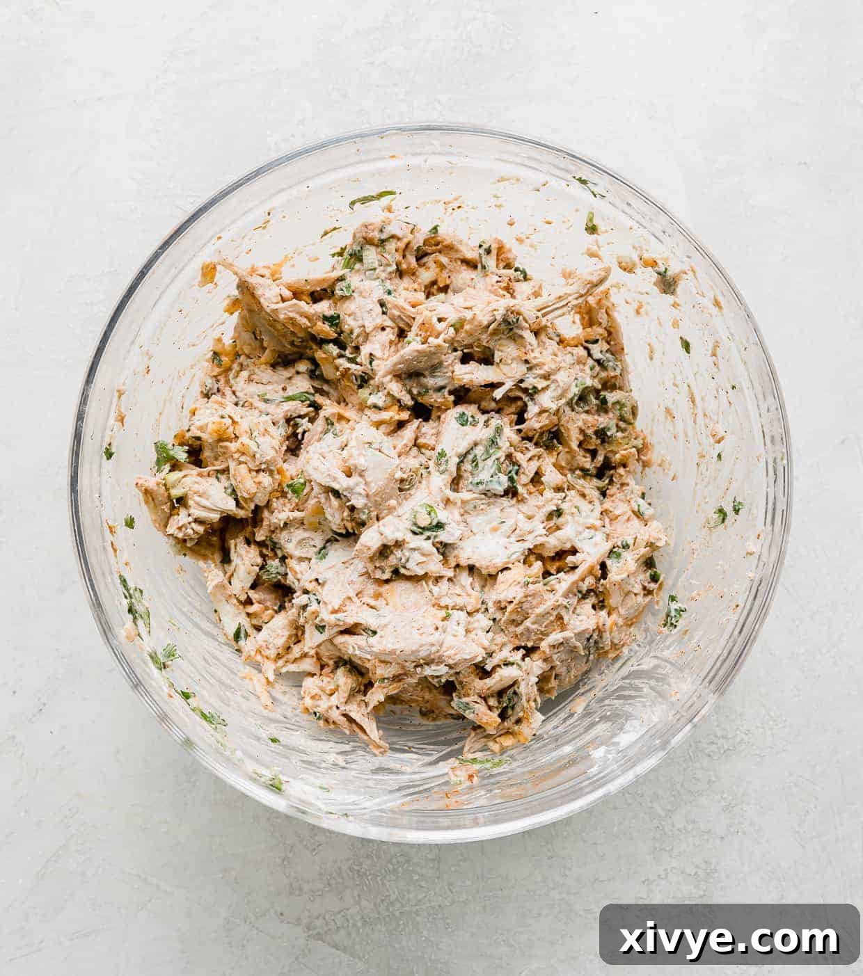 Baked Chicken Taquitos filling ingredients mixed together in a glass bowl.