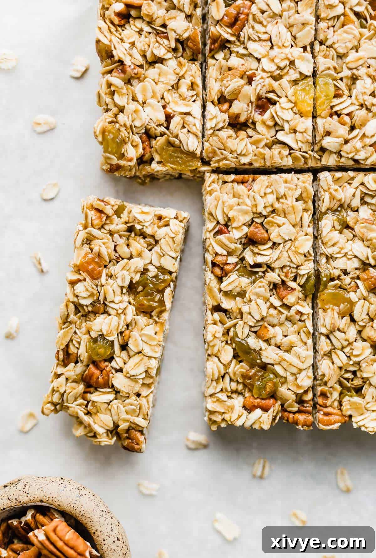 Wholesome Oat & Raisin Granola Bars 8 Homemade granola bars filled with rolled oats, nuts, and golden raisins, cut into bars on a white background.