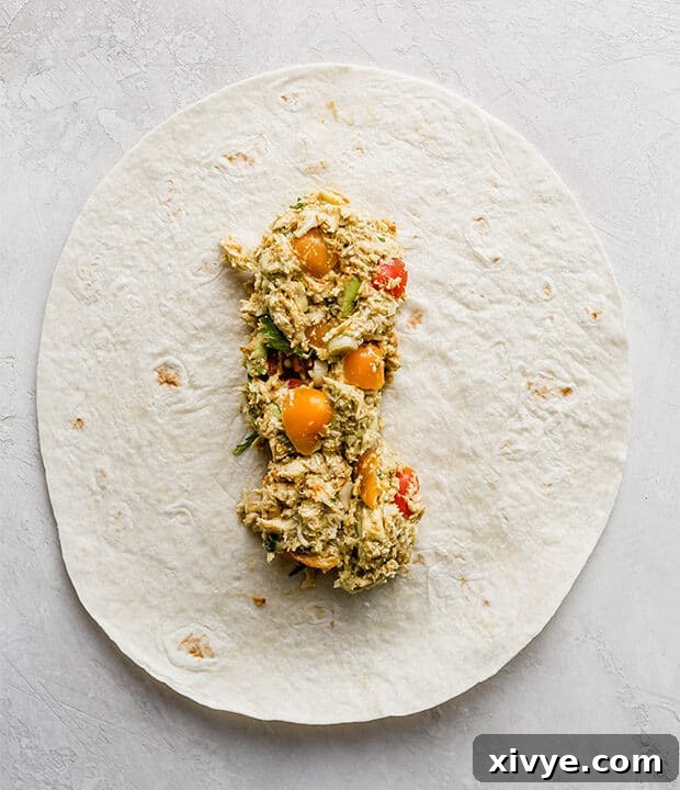 Creamy Avocado Chicken Wraps 7 A flour tortilla being filled with the creamy avocado chicken mixture.