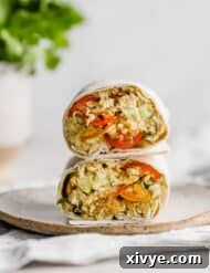 An Avocado Chicken Wrap cut in half, with the halves stacked on top of one another.