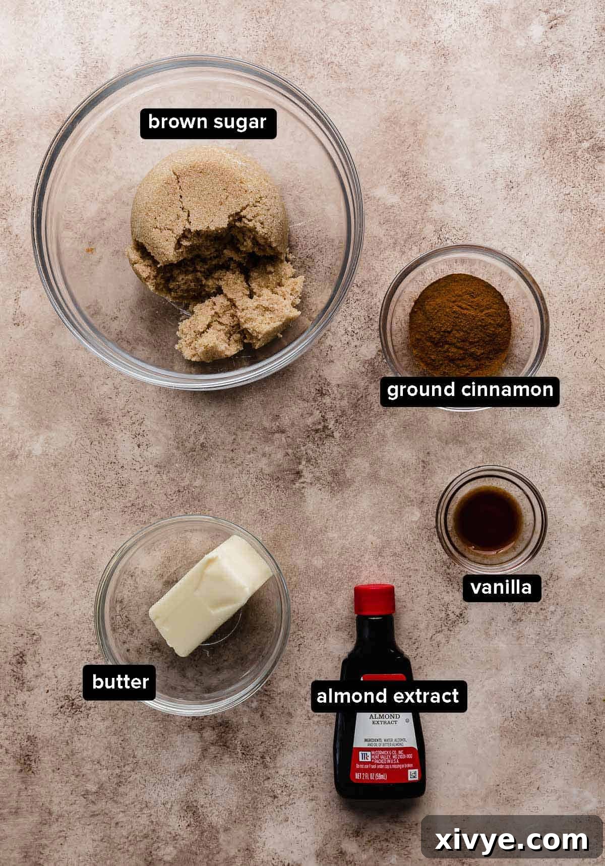 Cinnamon roll mixture portioned into glass bowls on a brown background.