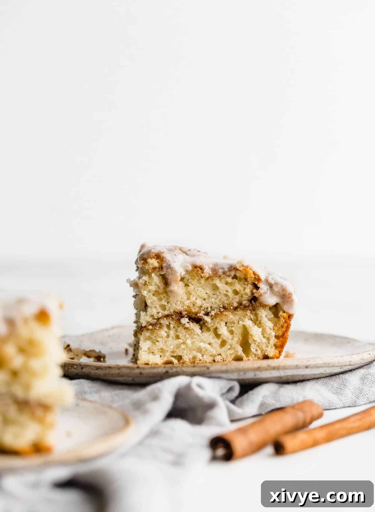 A slice of cinnamon roll sheet cake on a white plate, ready to be enjoyed.