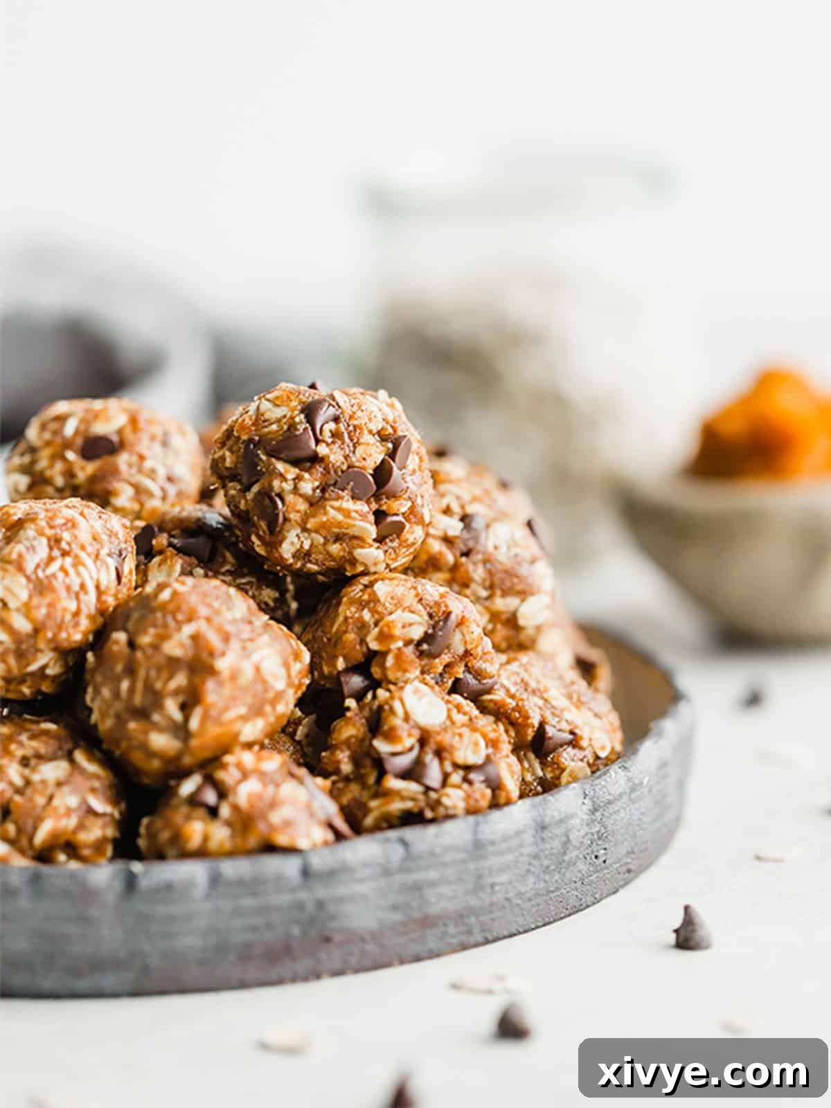 Pumpkin Energy Balls on a black plate, artfully arranged to showcase their texture and warmth.