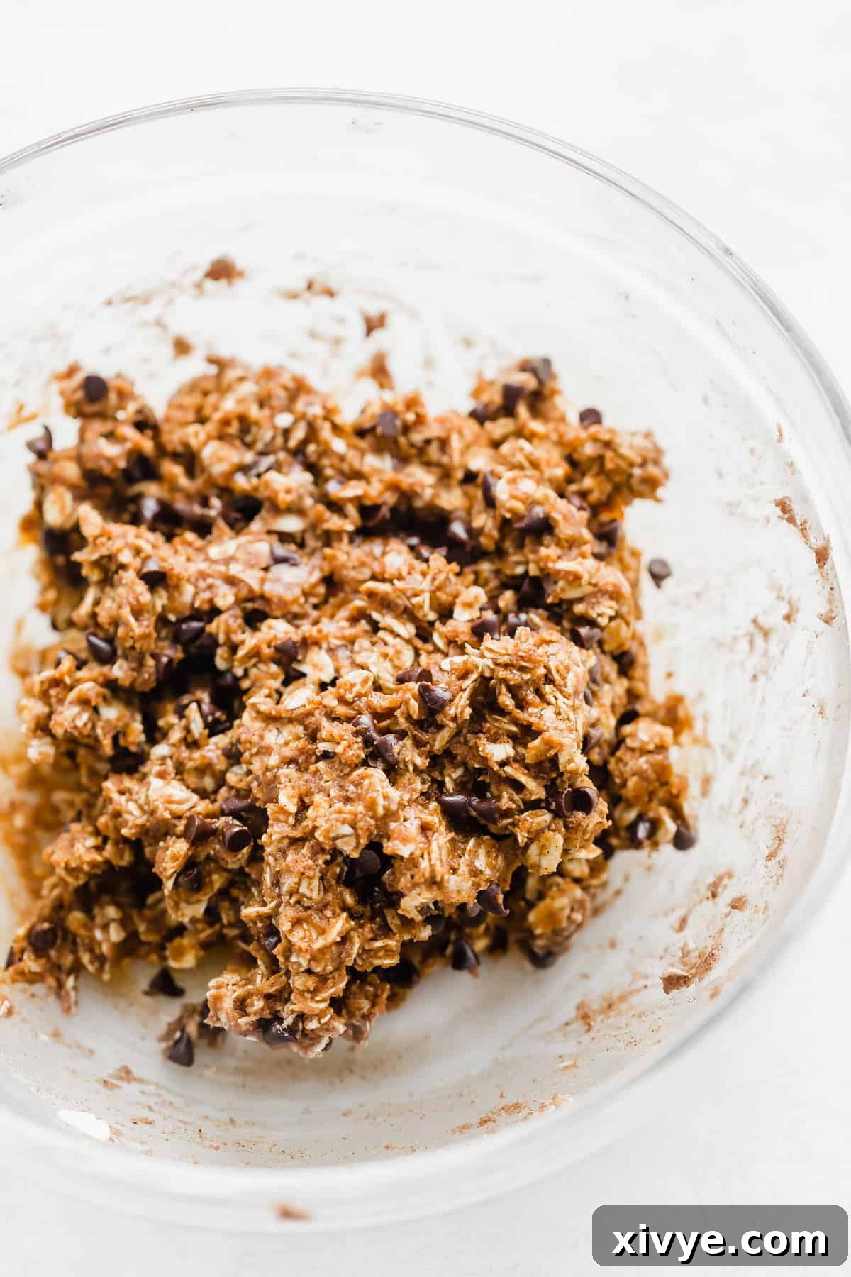 The pumpkin energy ball ingredients thoroughly mixed in a bowl, forming a thick, uniform dough.