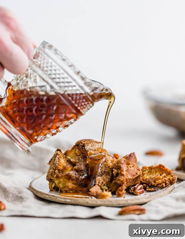 Spiced Pumpkin French Toast Bake 3 Maple syrup generously poured over a serving of Overnight Pumpkin French Toast Casserole.