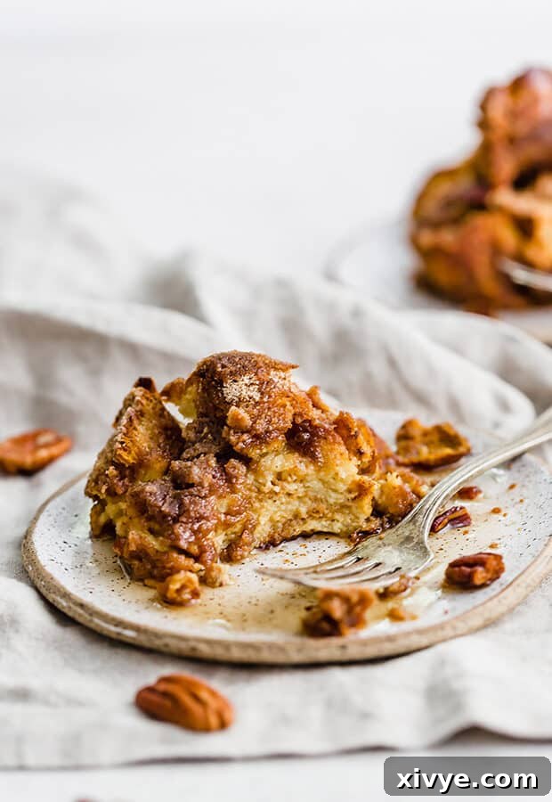 Spiced Pumpkin French Toast Bake 10 A bite taken out of a portion of the overnight pumpkin French toast casserole, showing its tender interior and crunchy topping.