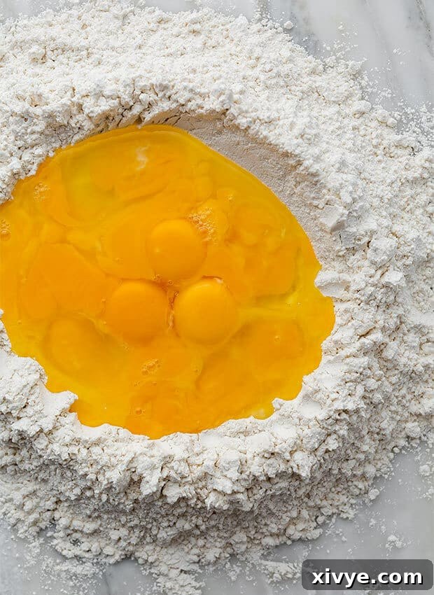 Mastering Ravioli Making 3 Eggs and egg yolks filling a flour mound.