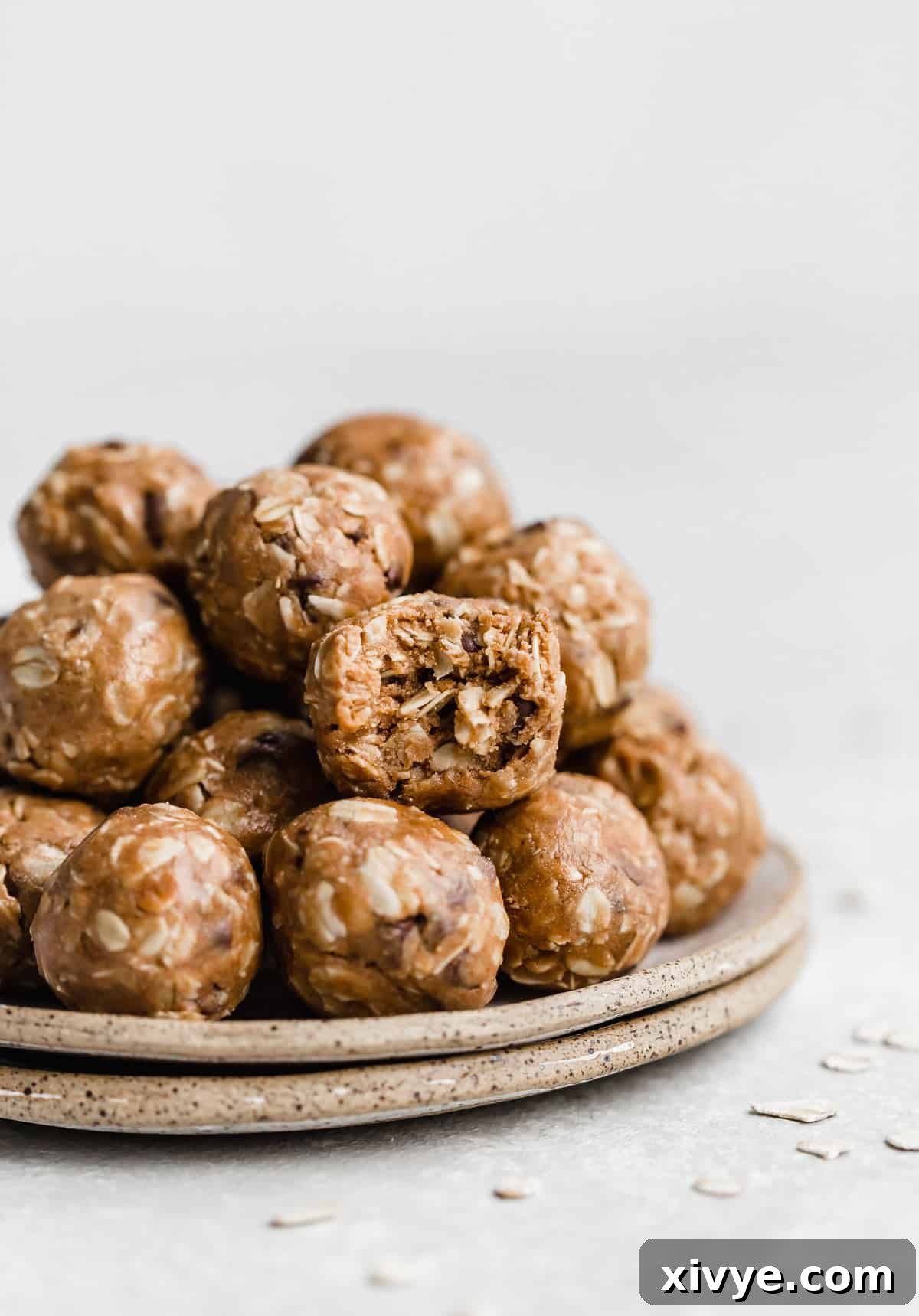Delicious Chocolate Peanut Butter Protein Balls on a plate, with one bitten to reveal its creamy center.