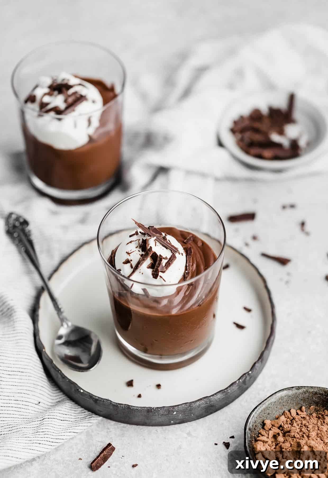 Velvety Chocolate Dream 11 Homemade Dark Chocolate Pudding in a elegant glass cup topped with freshly whipped cream and delicate chocolate shavings, inviting and rich.