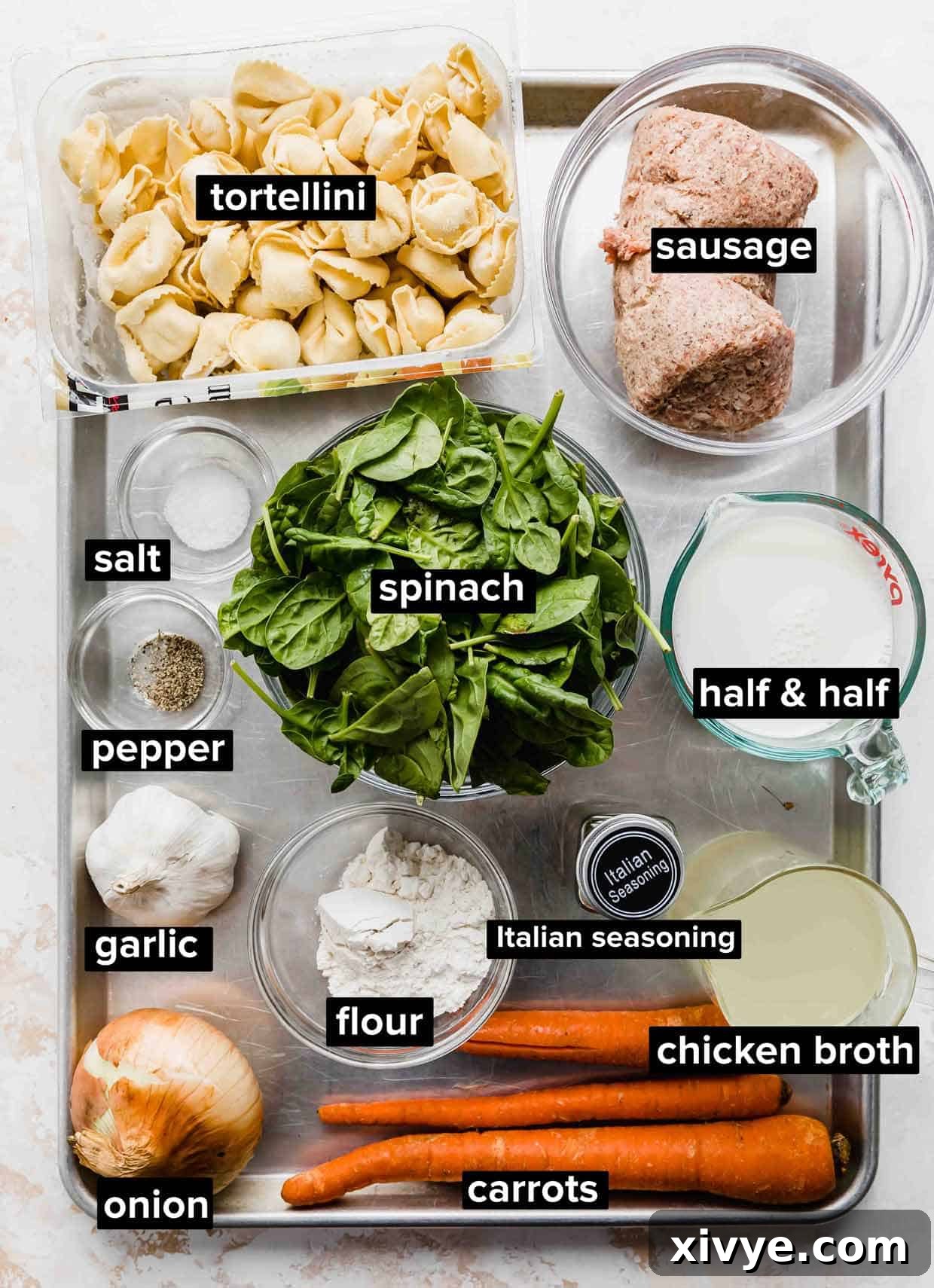 Hearty Italian Sausage Tortellini Soup 3 Sausage Tortellini Soup ingredients portioned out onto a baking sheet.