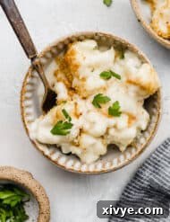 Cauliflower Gratin in a ceramic bowl garnished with fresh parsley.