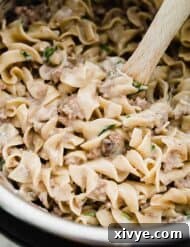 An instant pot filled with creamy ground beef stroganoff, garnished with fresh herbs.