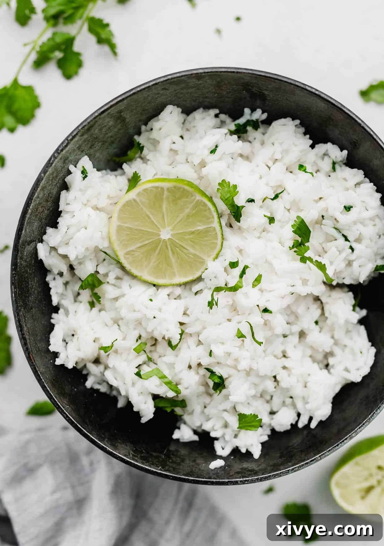 A black bowl with Cilantro Lime Rice in it that's topped with a circle lime slice.
