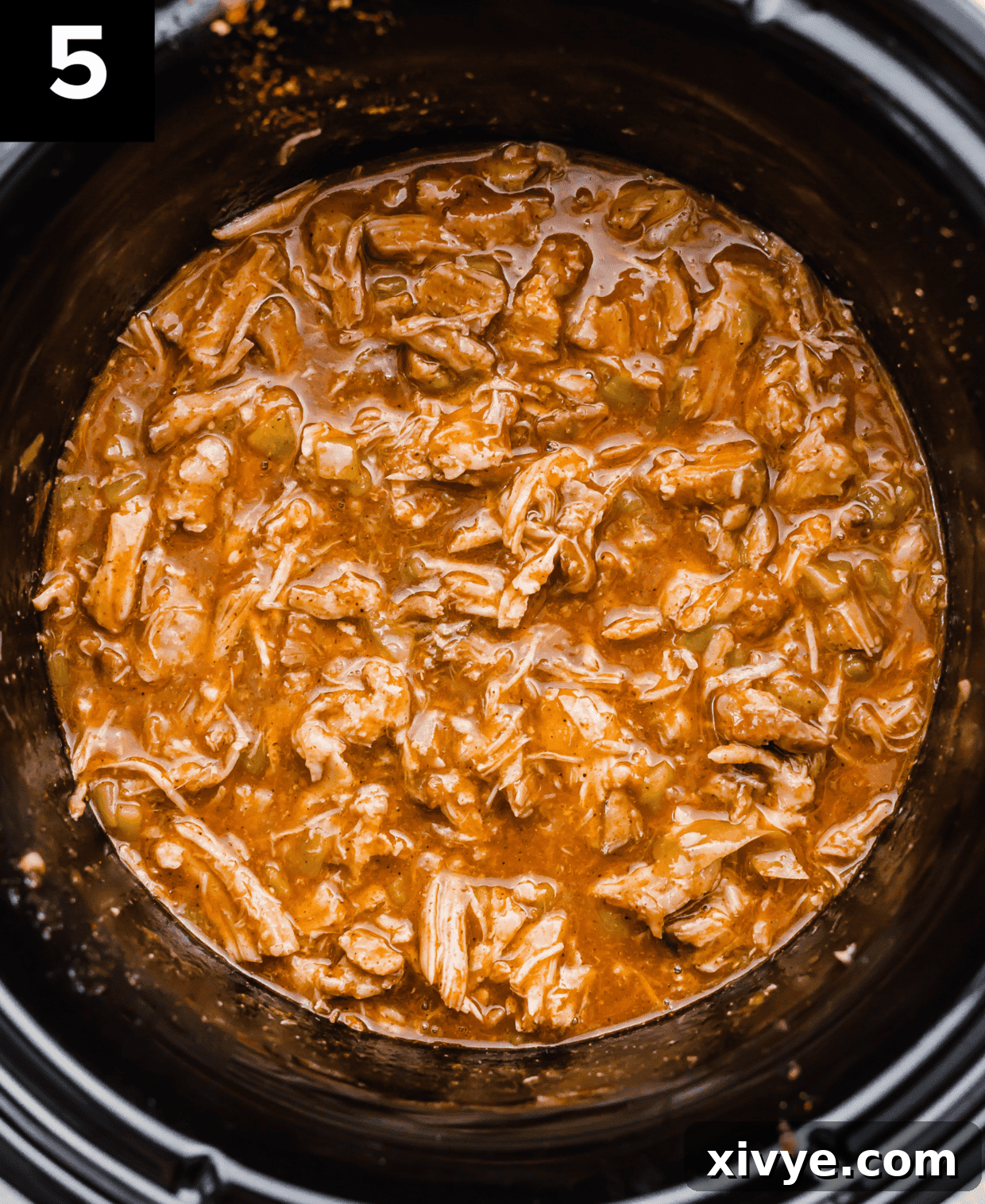 Cafe Rio Sweet Pork in a black slow cooker, ready to be served and enjoyed.