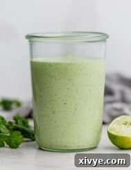 Cafe Rio Cilantro Lime Dressing in a jar with cilantro to the side, ready for serving.