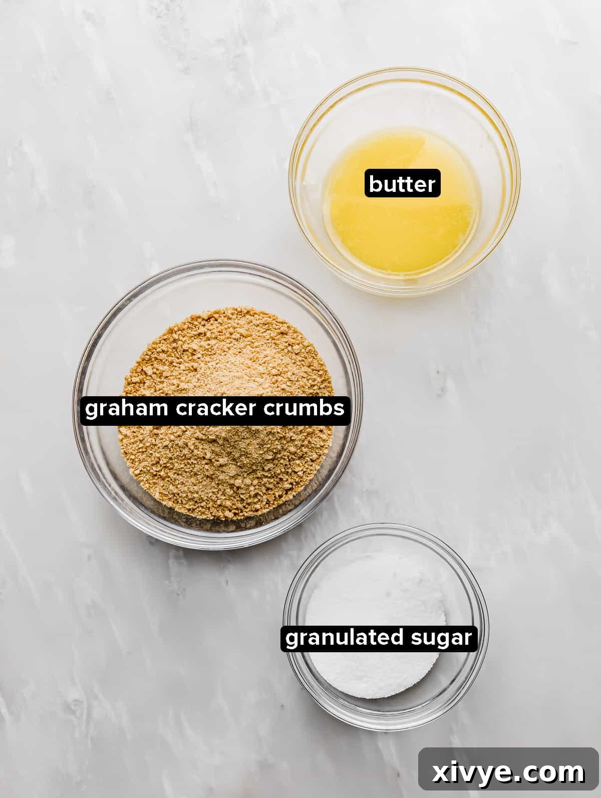 Graham Cracker Crumble Base 3 Graham Cracker Crust ingredients on a white marble background.