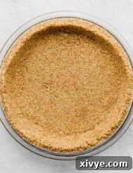 A homemade Graham Cracker Crust pressed into a pie plate on a light gray background.