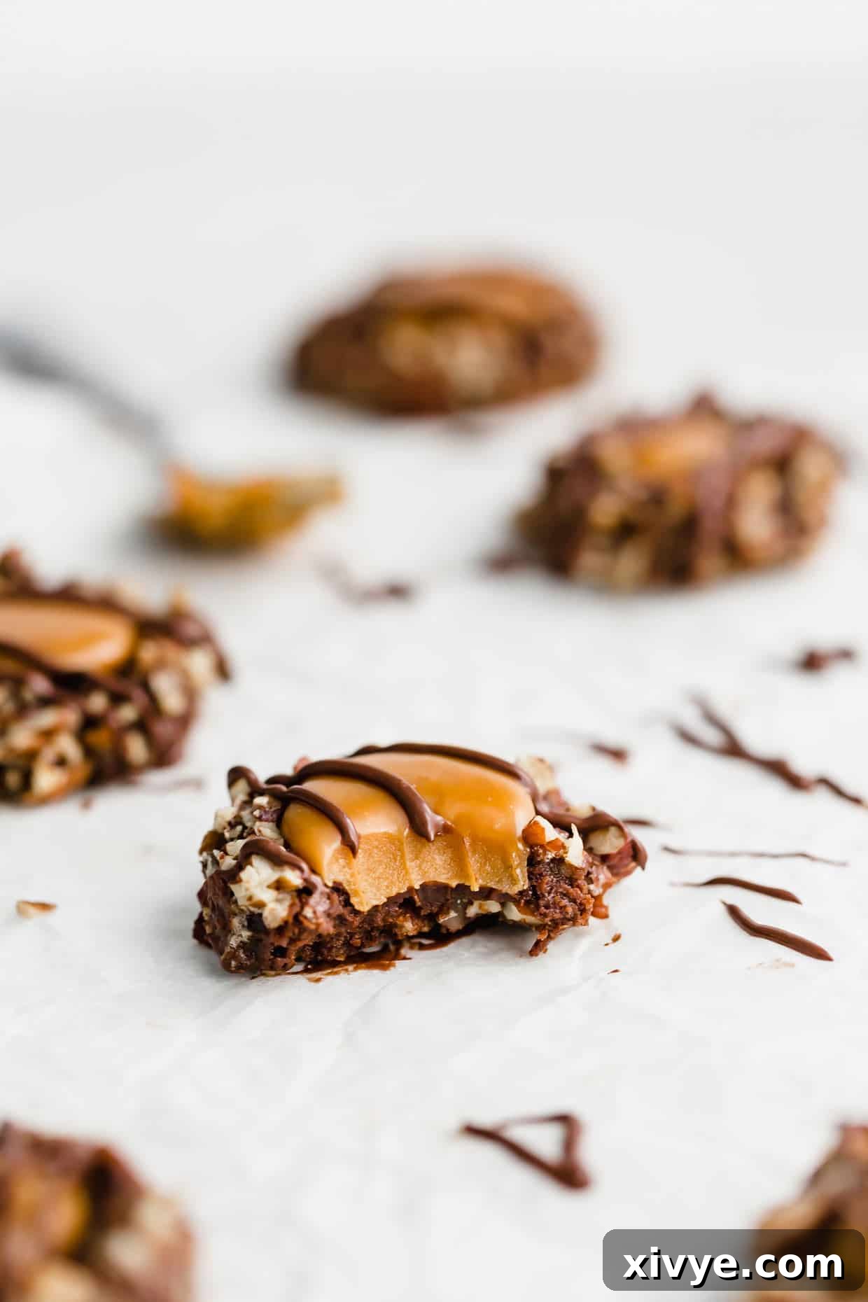 A bite taken out of a Turtle Cookie that's drizzled with chocolate. 