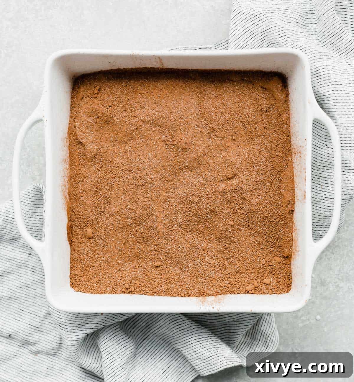 Molten Chocolate Dream 6 A brown colored sugar mixture overtop a hot fudge cake batter in a white square pan.